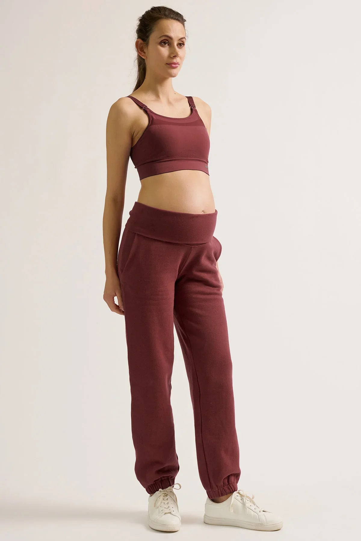 Donna con pantaloni jogger premaman e top coordinato color prugna di Cache Coeur.
