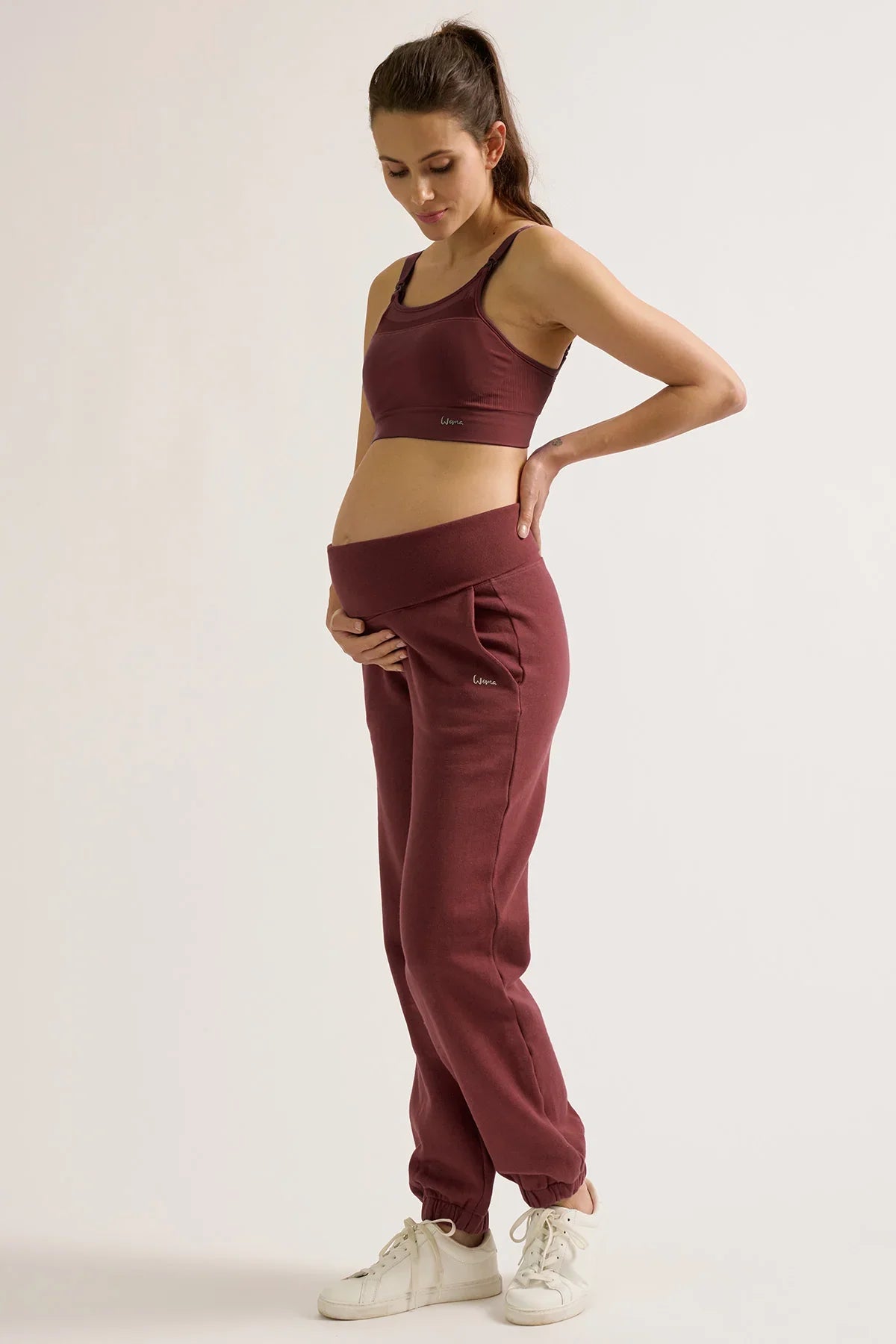 Donna con pantaloni jogger premaman e top coordinato colore prugna firmati Cache Coeur