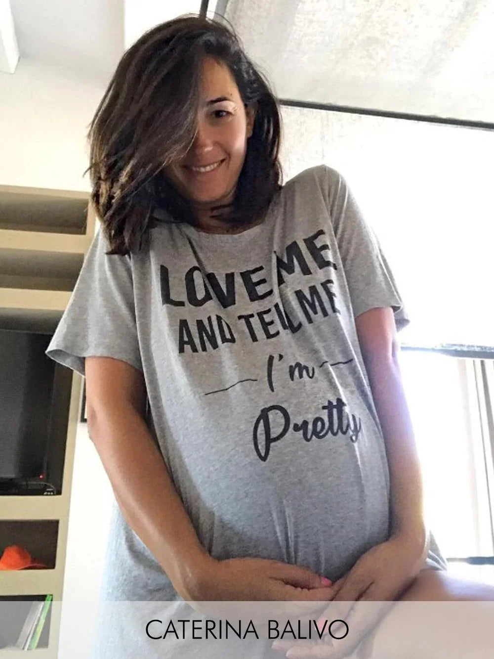 Donna che indossa una t-shirt premaman grigia con scritta nera