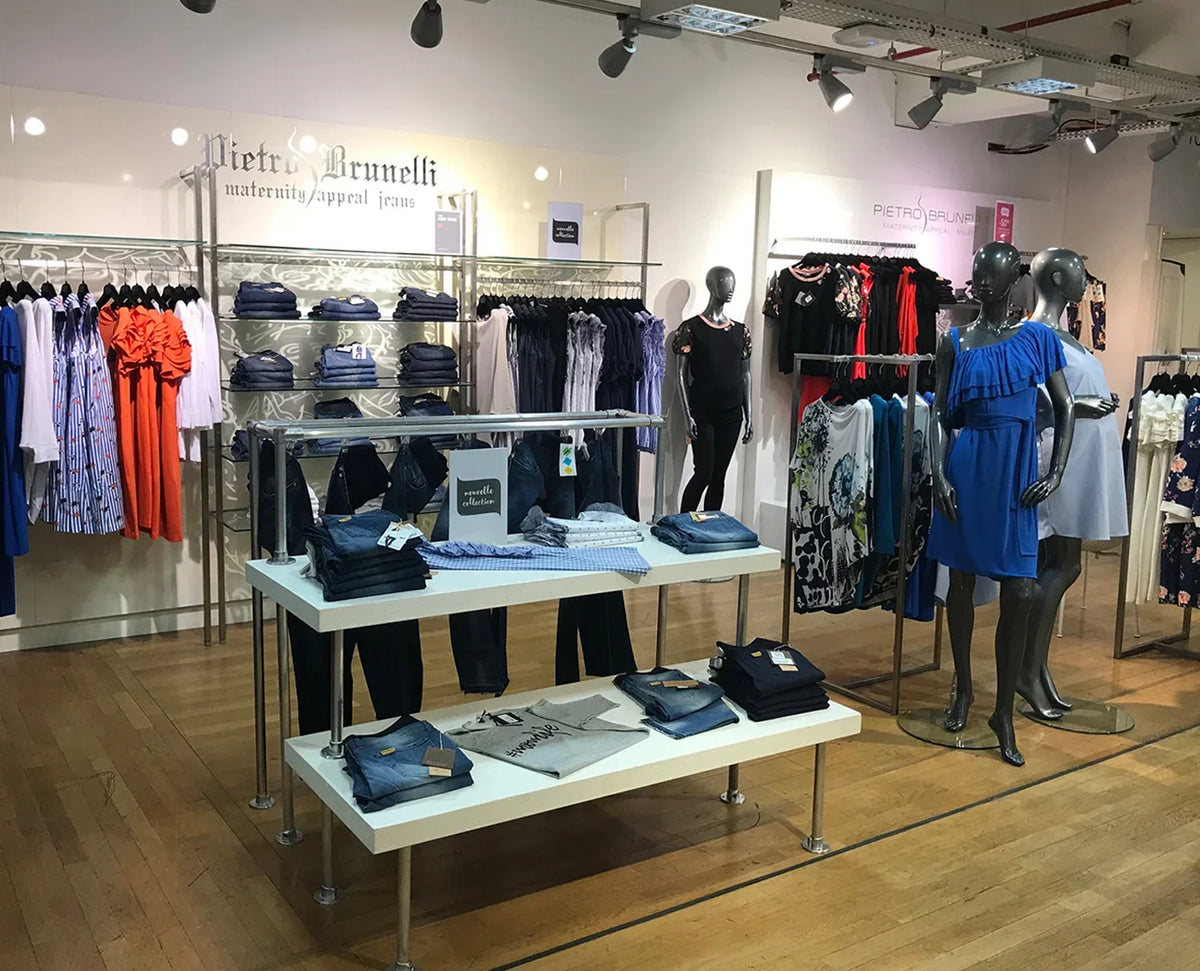 Interno negozio con abiti premaman, jeans premaman e pantaloni premaman esposti.