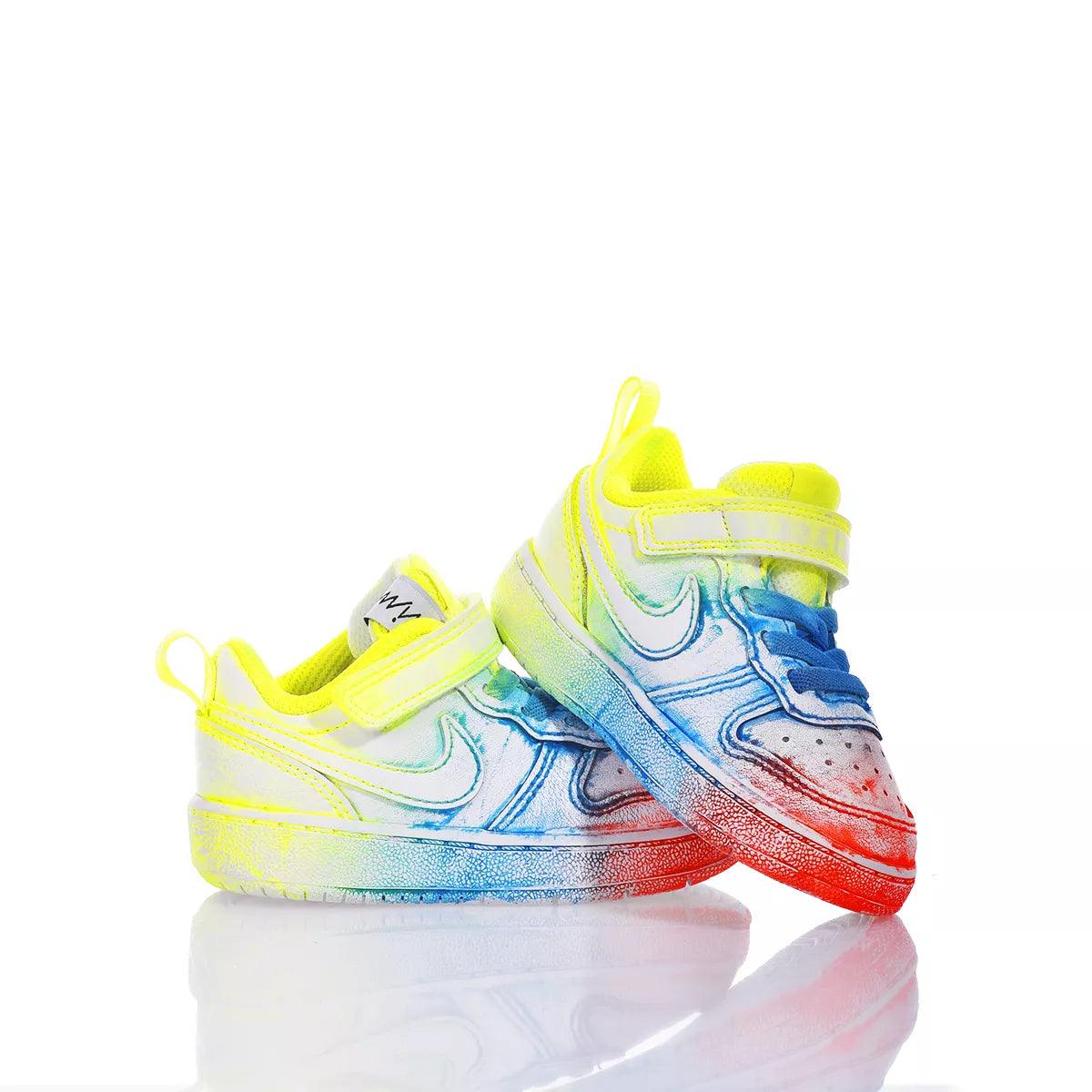 Scarpe da ginnastica bambino colorate con dettagli giallo fluo, blu e rosso, fondo bianco.