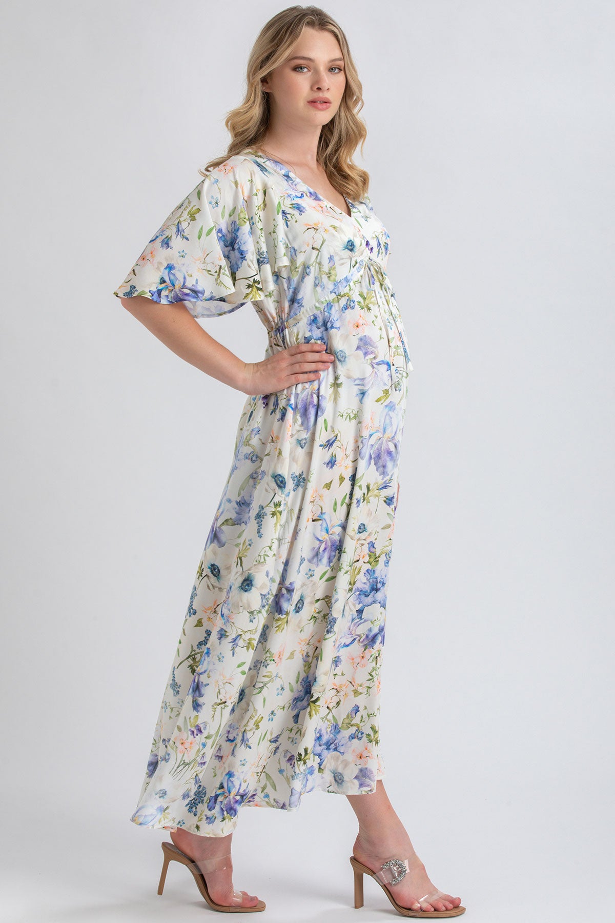 Donna incinta con abito premaman lungo floreale elegante e sandali con tacco