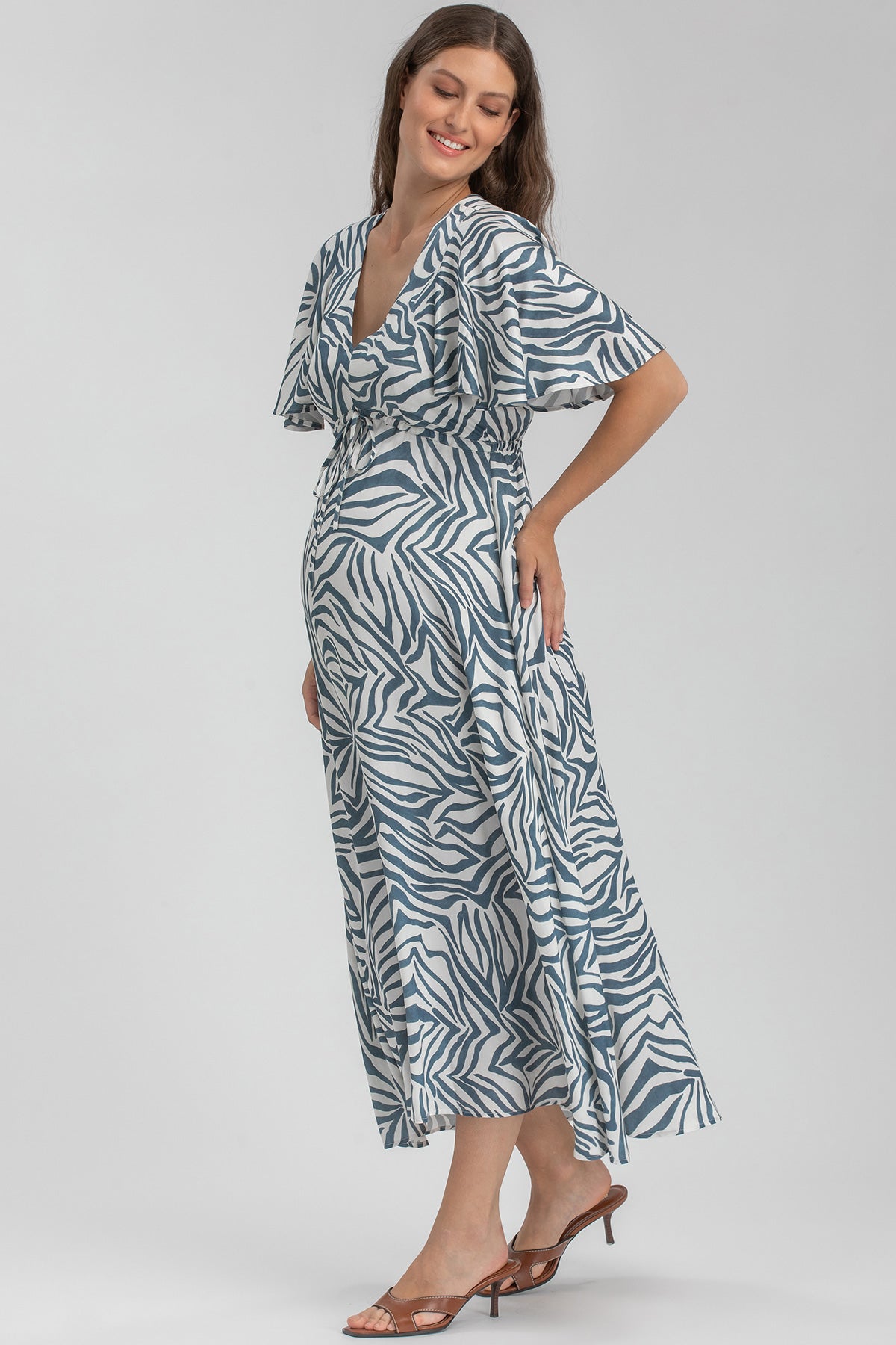 Abito premaman elegante fantasia zebra, donna incinta sorridente su sfondo neutro