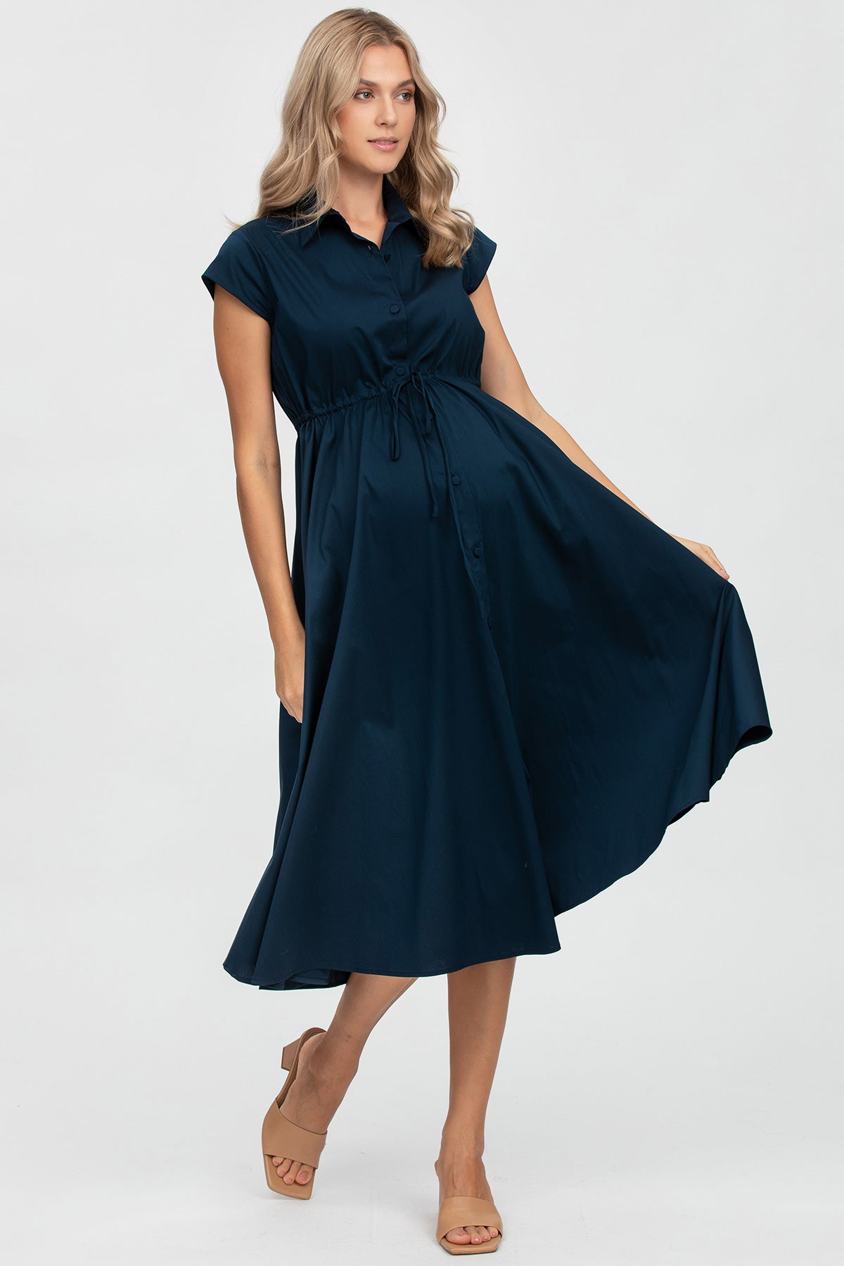 Vestito premaman blu elegante con taglio svasato e cintura in vita, indossato da modella.