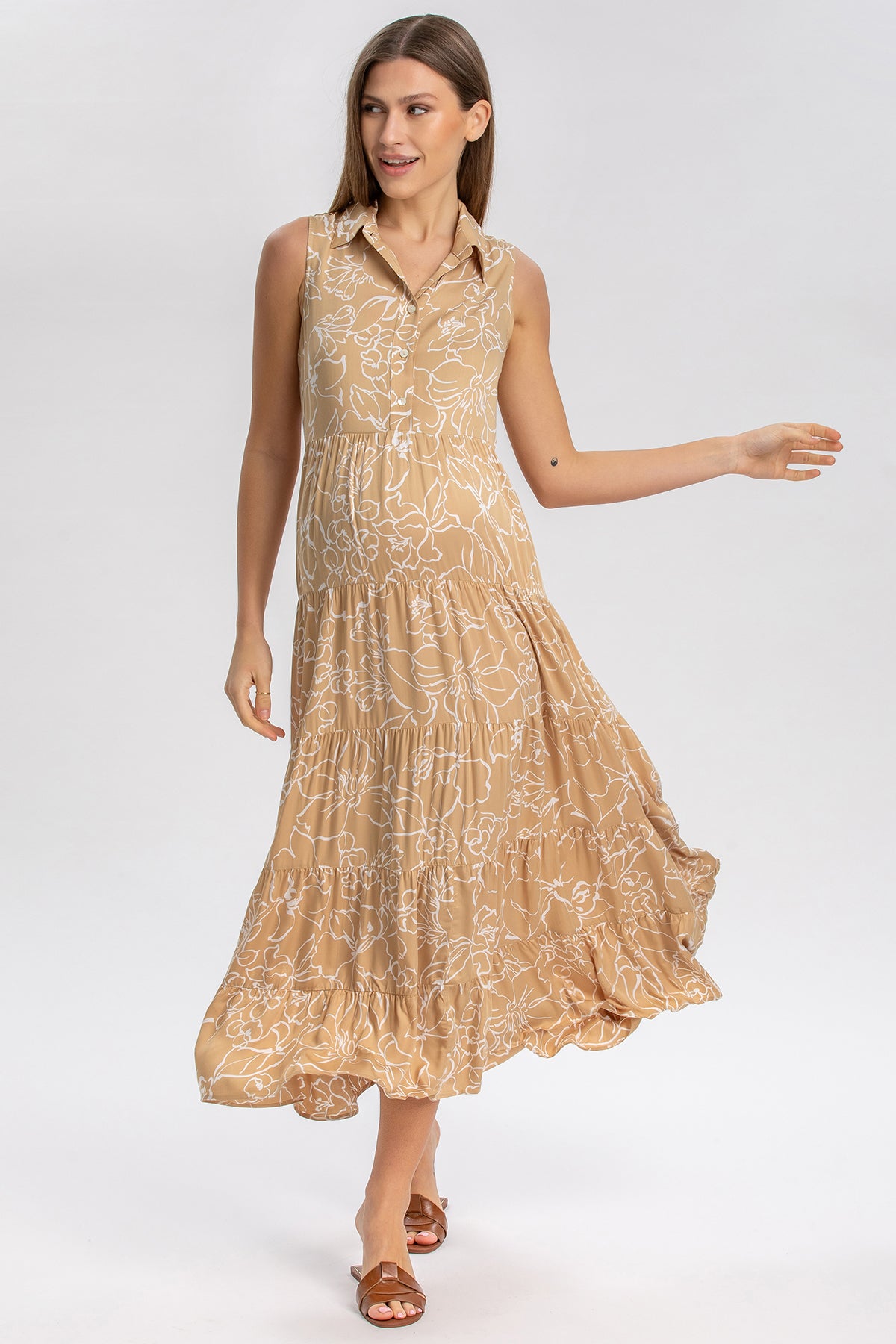 Vestito premaman elegante beige senza maniche con stampa floreale, modello midi.
