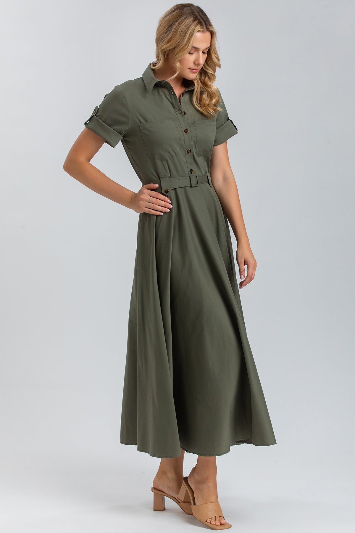 Abito premaman lungo verde oliva con cintura, maniche corte e colletto, donna in posa.