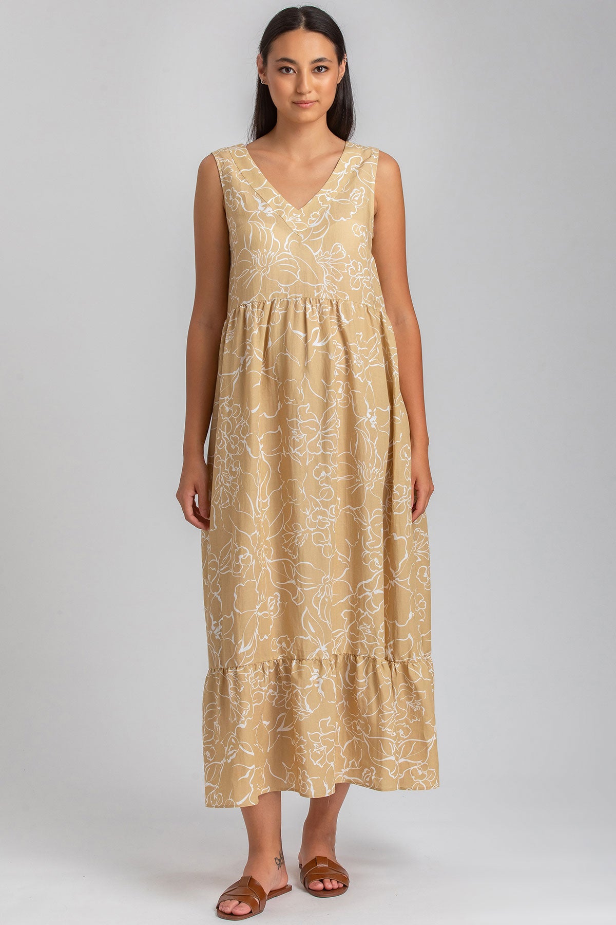 Abito premaman lungo senza maniche beige con stampa floreale bianca, scollo a V.