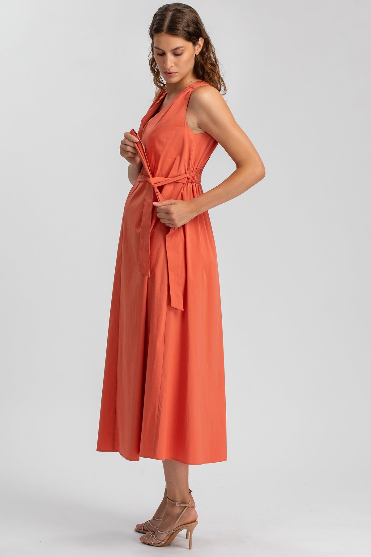 Abito premaman arancione senza maniche, lungo, con cintura, look elegante e confortevole.