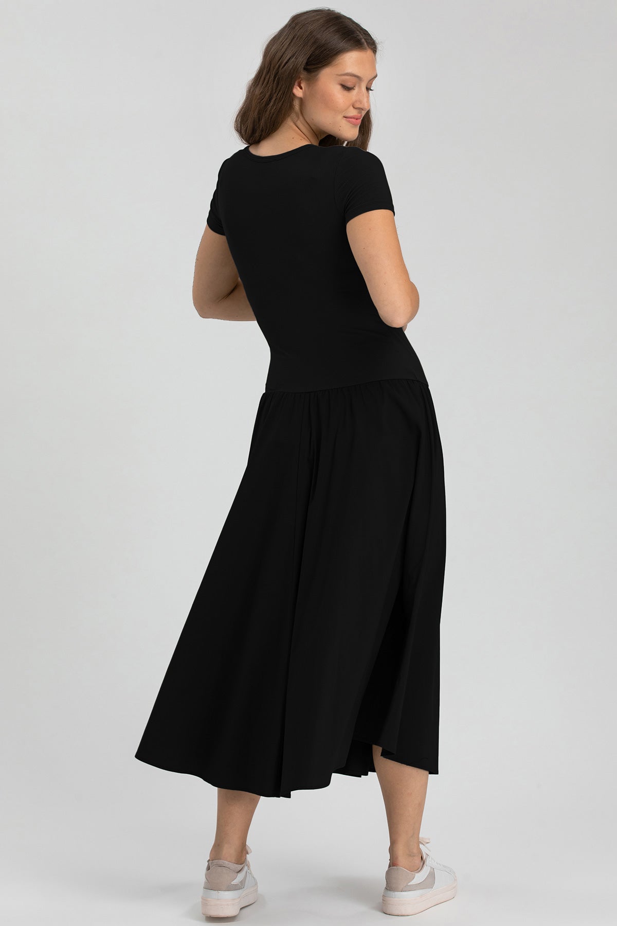 Abito premaman nero midi a mezze maniche, donna di profilo, abbigliamento maternità elegante.