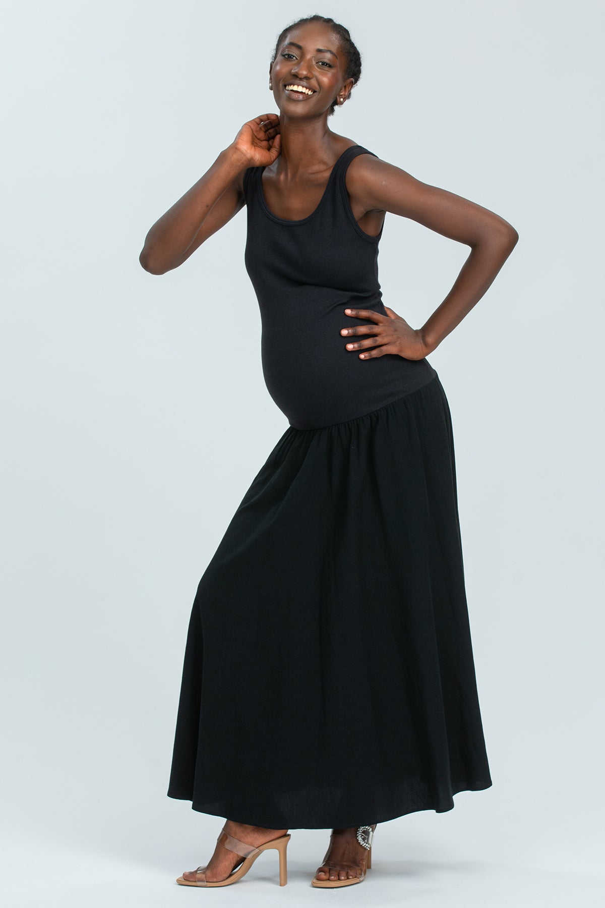 Abito premaman nero lungo elegante, perfetto per la gravidanza, indossato da una donna sorridente