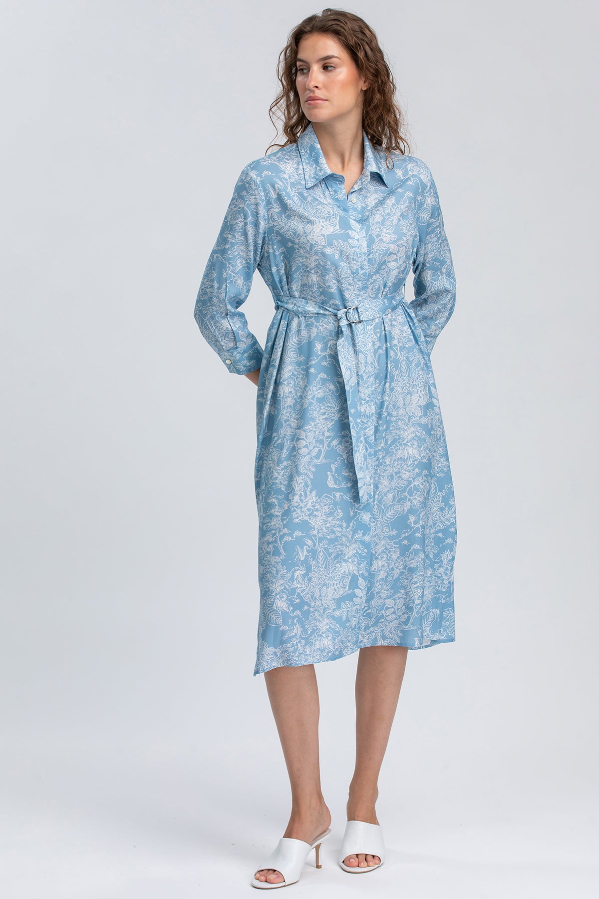 Abito premaman camicia azzurro a fantasia floreale con cintura, donna in piedi
