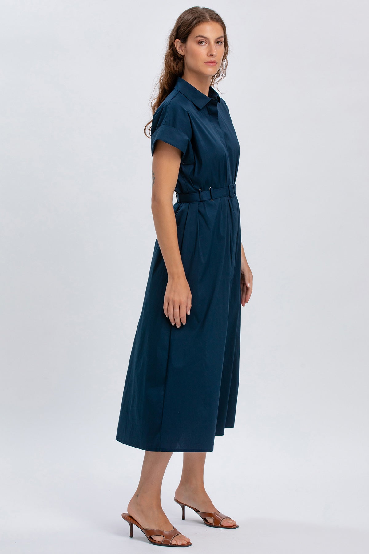 Abito premaman blu elegante con cintura, maniche corte e gonna midi, su sfondo chiaro.