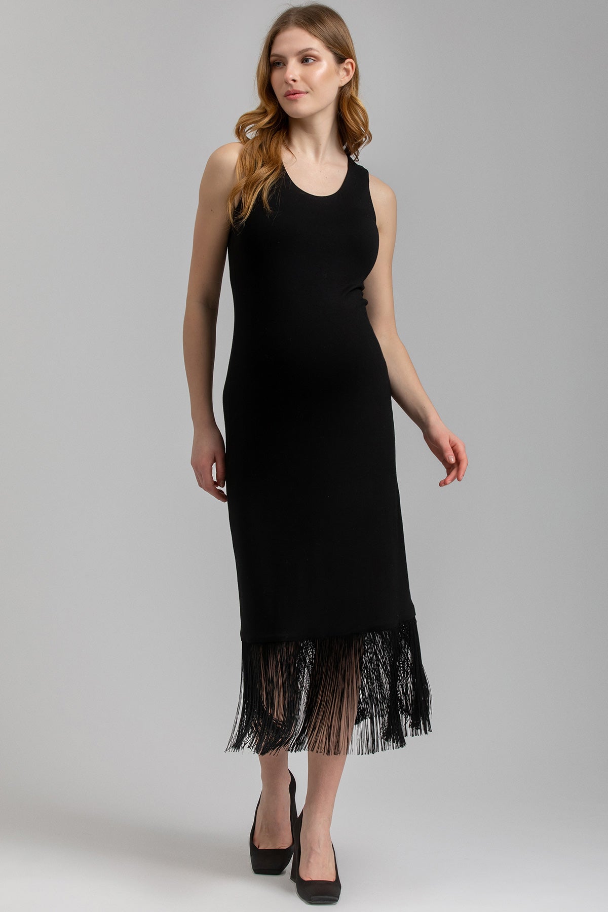 Abito premaman nero smanicato con frange eleganti sull'orlo, modello donna incinta.