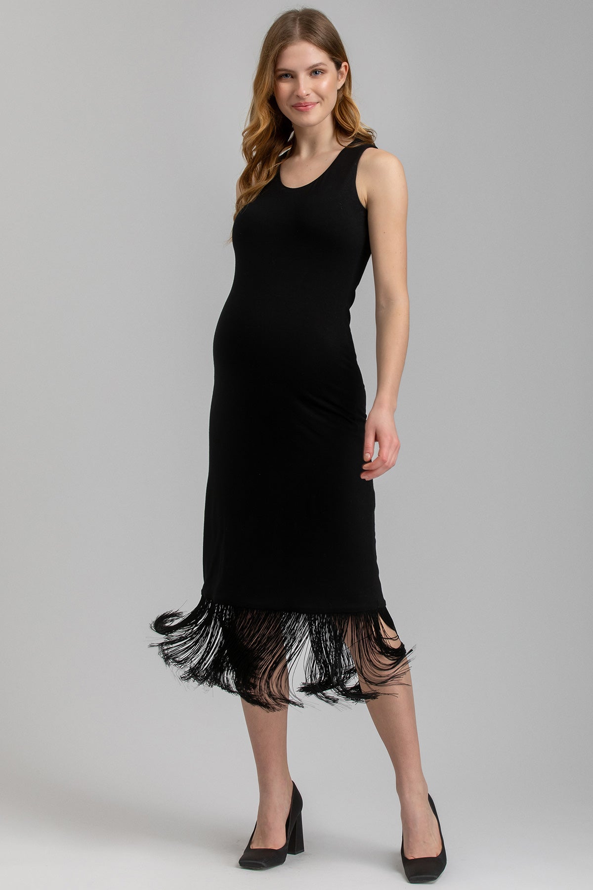 Vestito premaman nero elegante senza maniche con frange al fondo indossato da donna incinta