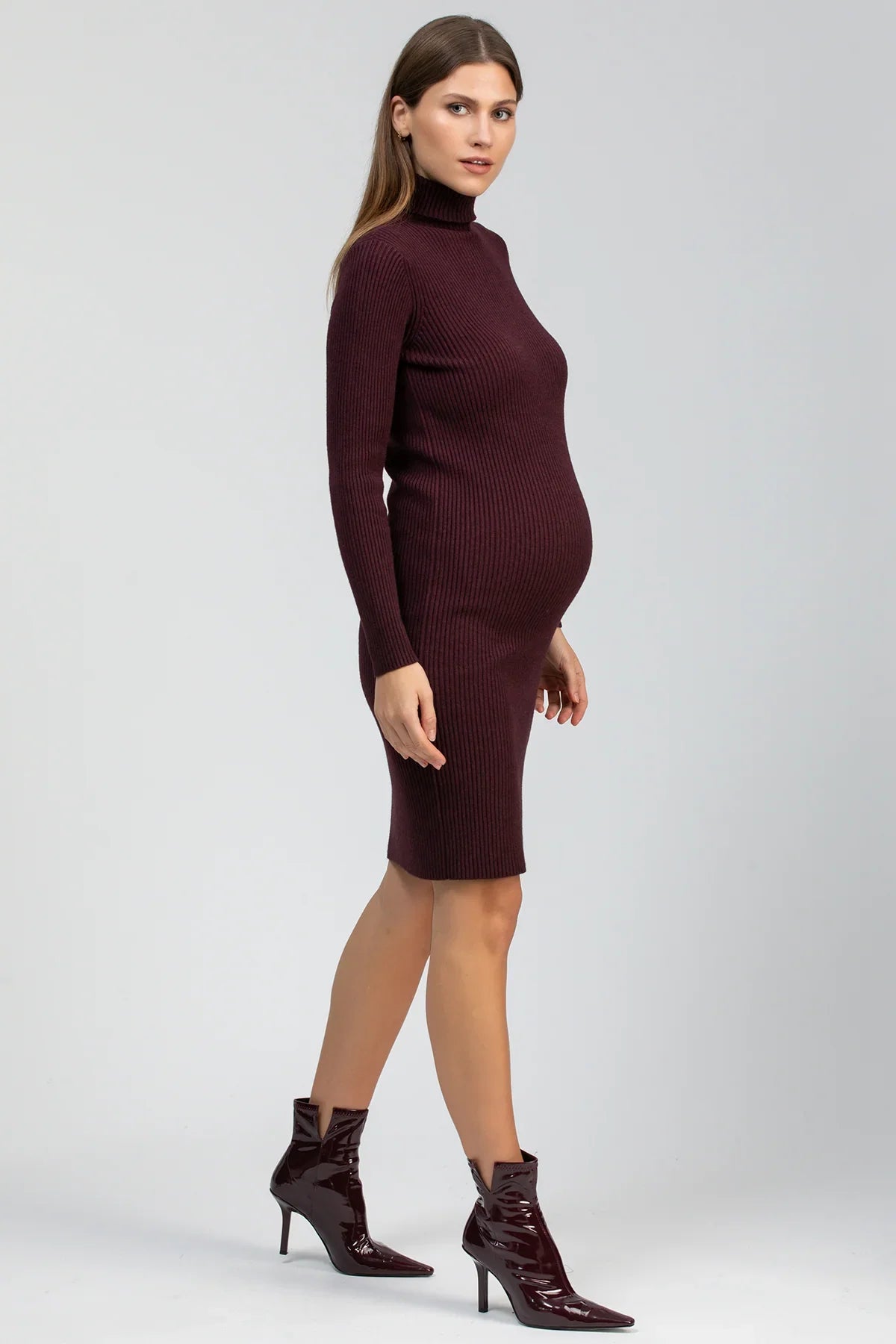 Modella indossa abito premaman bordeaux a collo alto in maglia, maniche lunghe