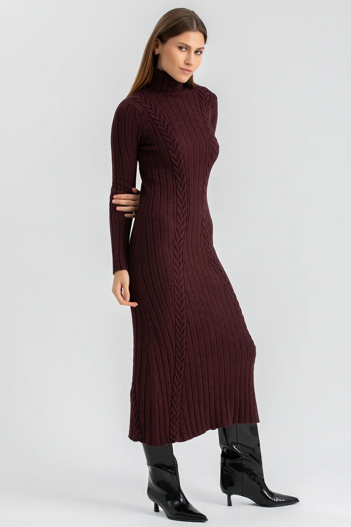 Abito premaman lungo bordeaux a coste con collo alto e stivali neri, donna in posa elegante