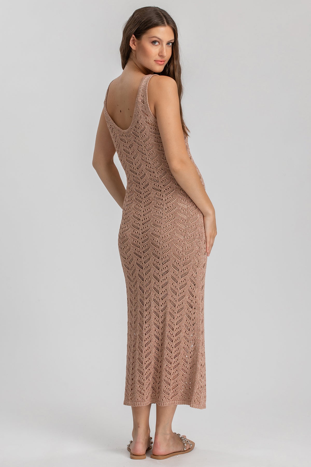 Abito premaman beige lungo in maglia traforata, ideale per gravidanza, donna di profilo