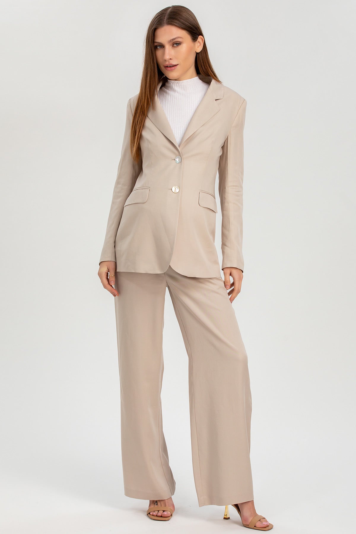 Completo premaman elegante beige con giacca e pantaloni larghi, moda maternità.