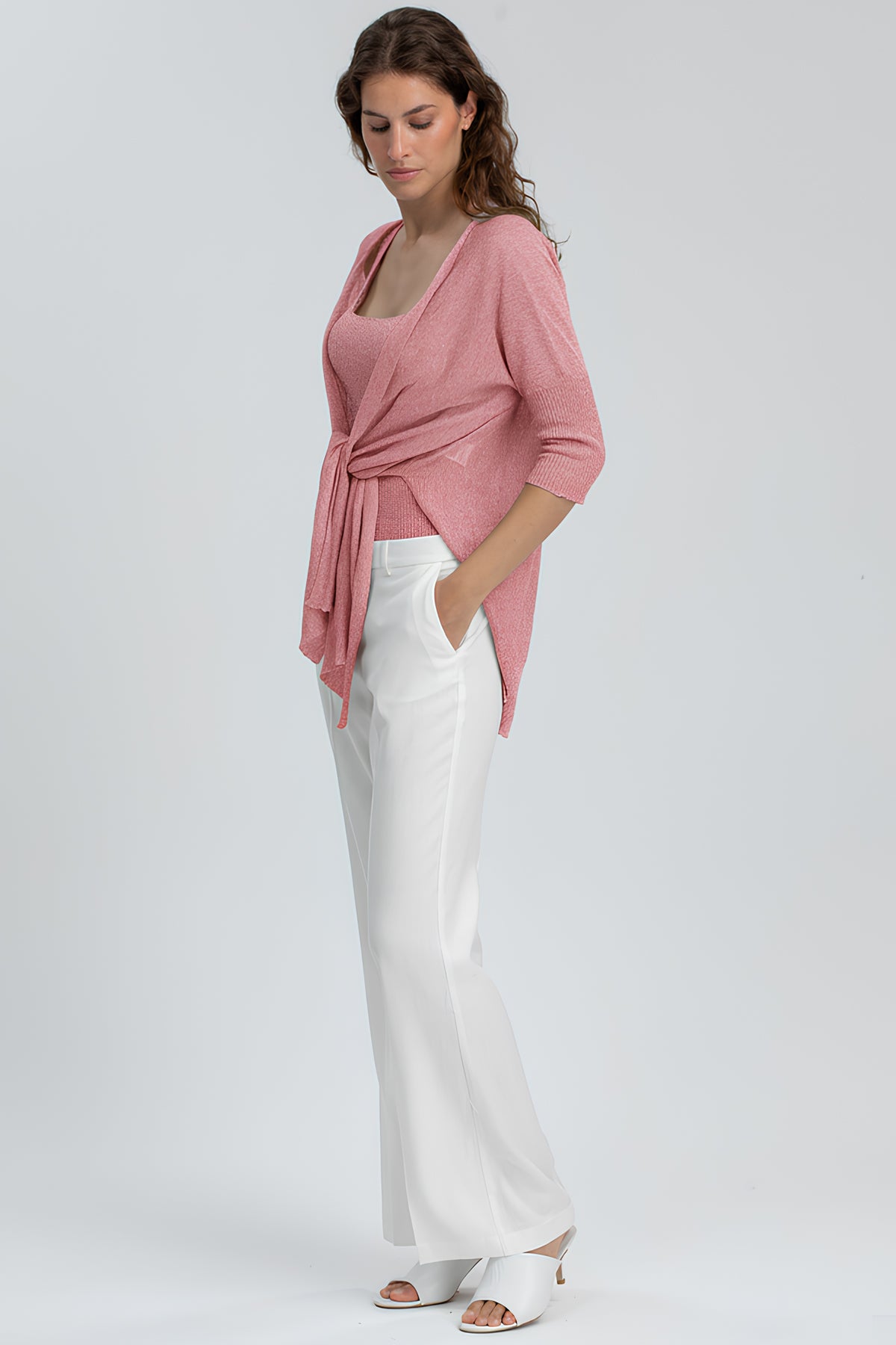 Outfit premaman elegante con cardigan rosa, top coordinato e pantaloni bianchi larghi
