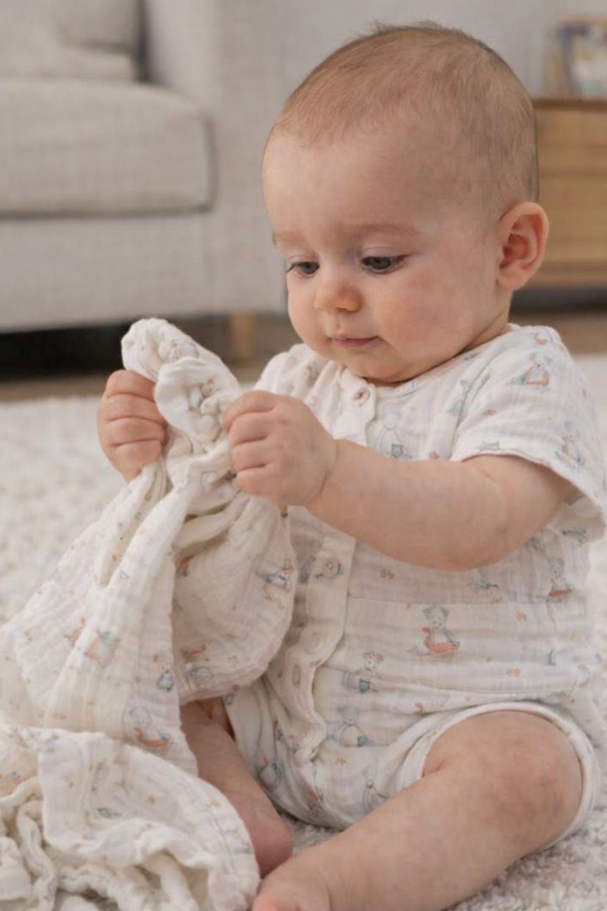 Bambino che indossa pagliaccetto premaman cotone fantasia seduto su tappeto, abbigliamento premaman