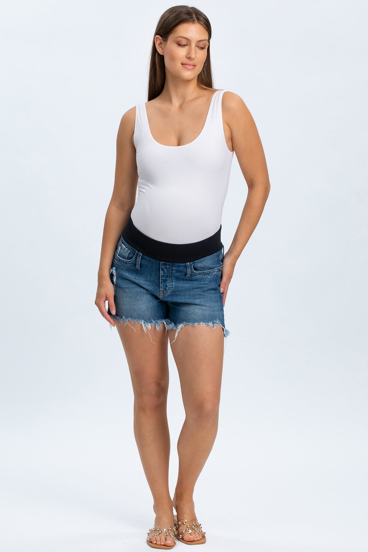 Shorts premaman in denim con fascia elastica nera e bordo sfrangiato, indossati da donna incinta.