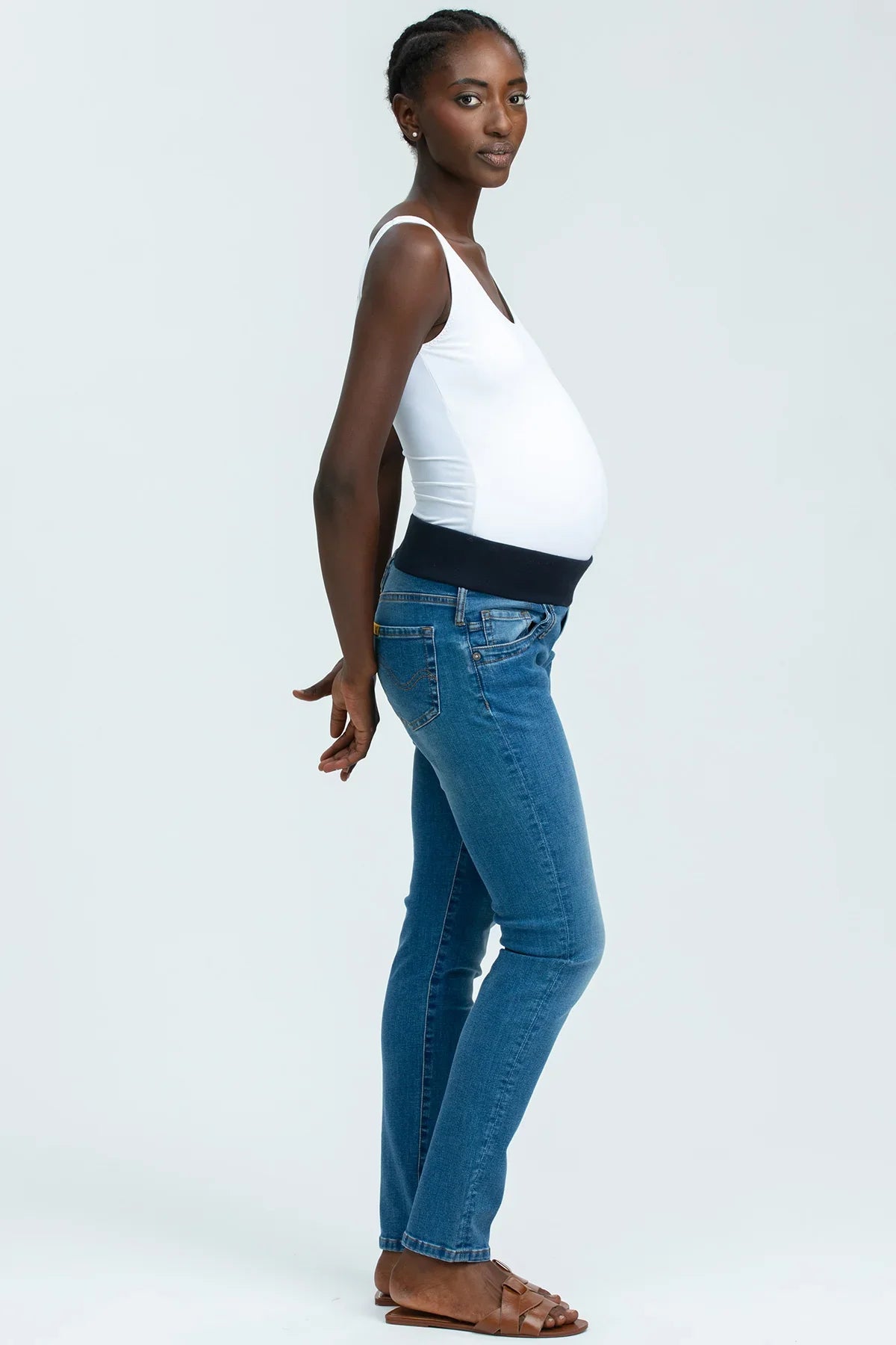 Modella indossa jeans premaman e top bianco, abbigliamento premaman comodo ed elegante