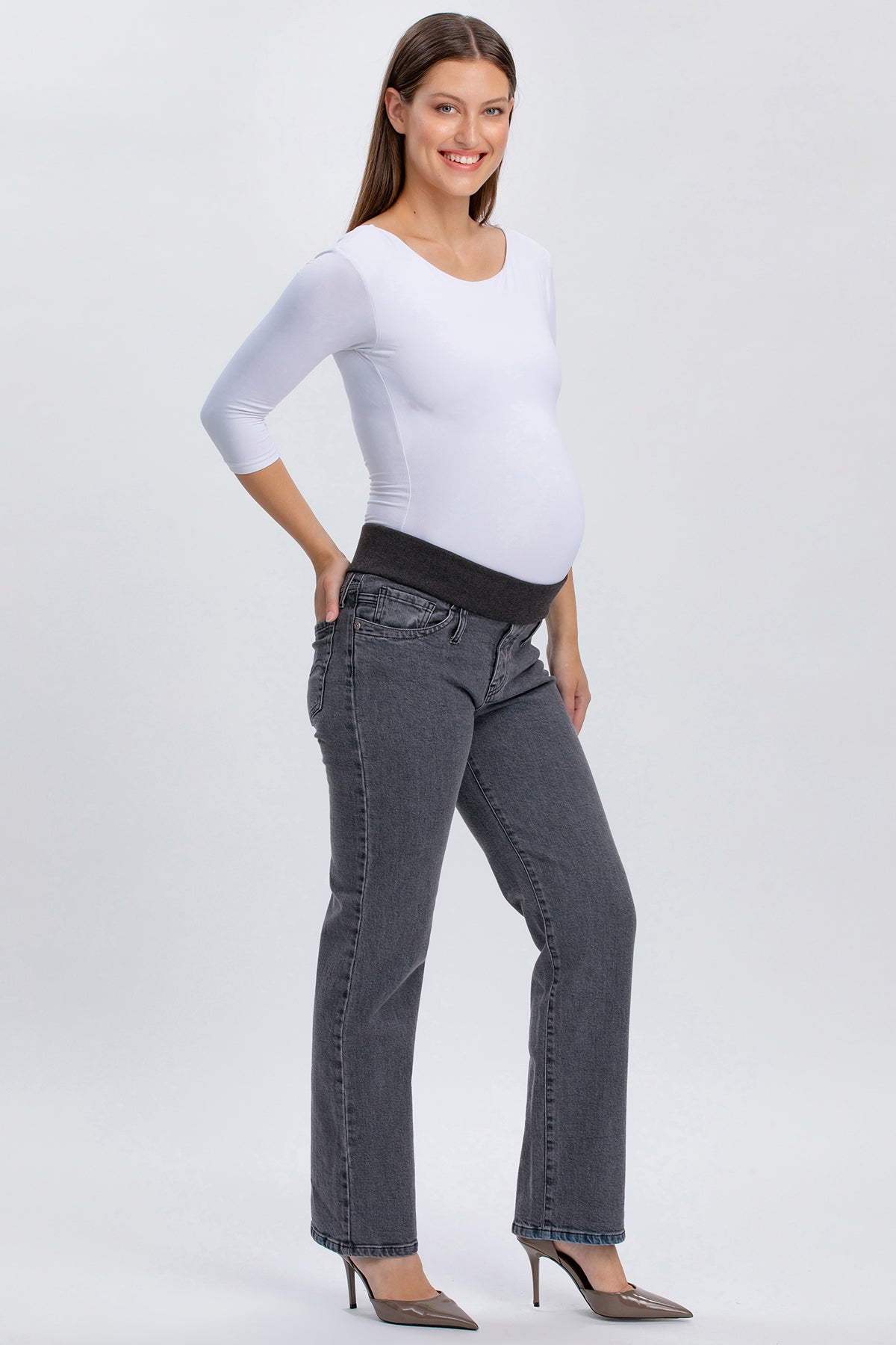 Modella indossa jeans premaman grigi a gamba dritta con fascia elastica nera.