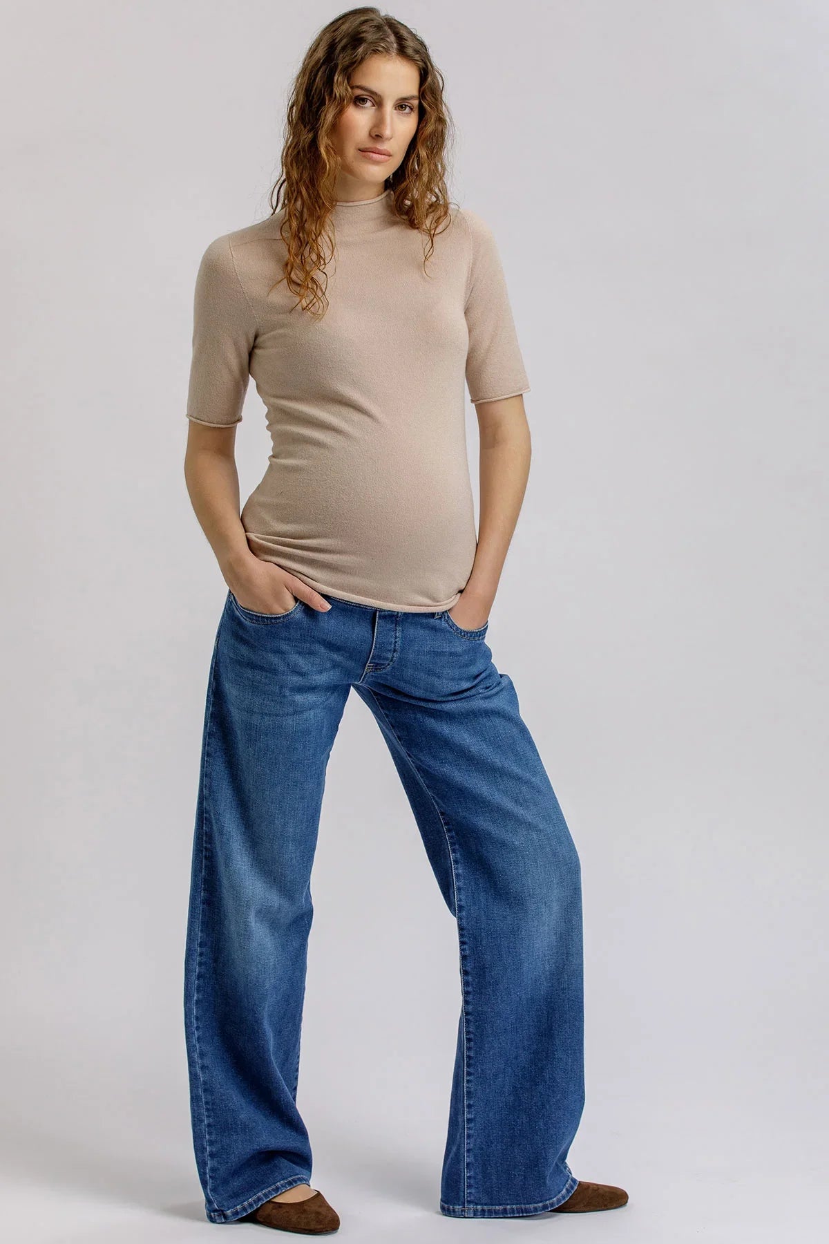 Beige maternity knit top with high neck.