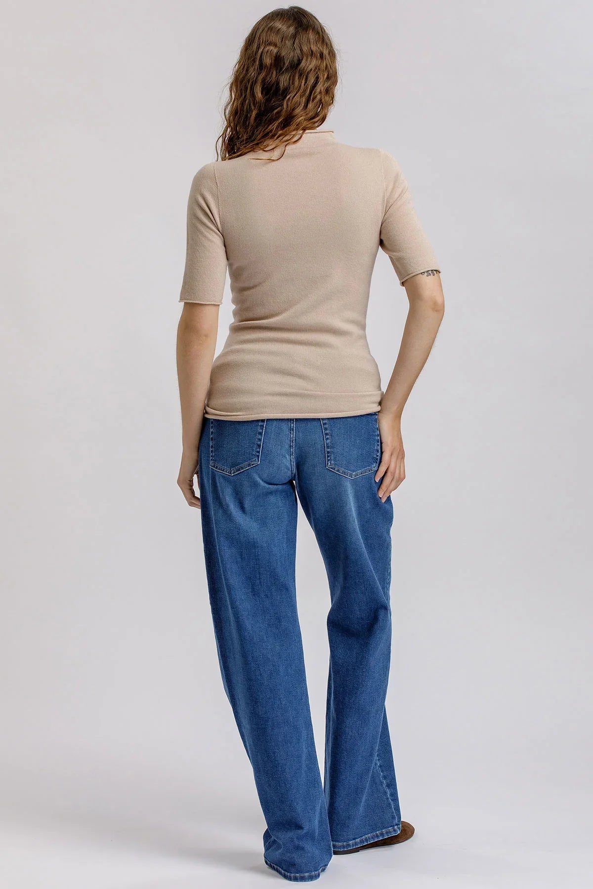 Fitted beige maternity top with short sleeves.