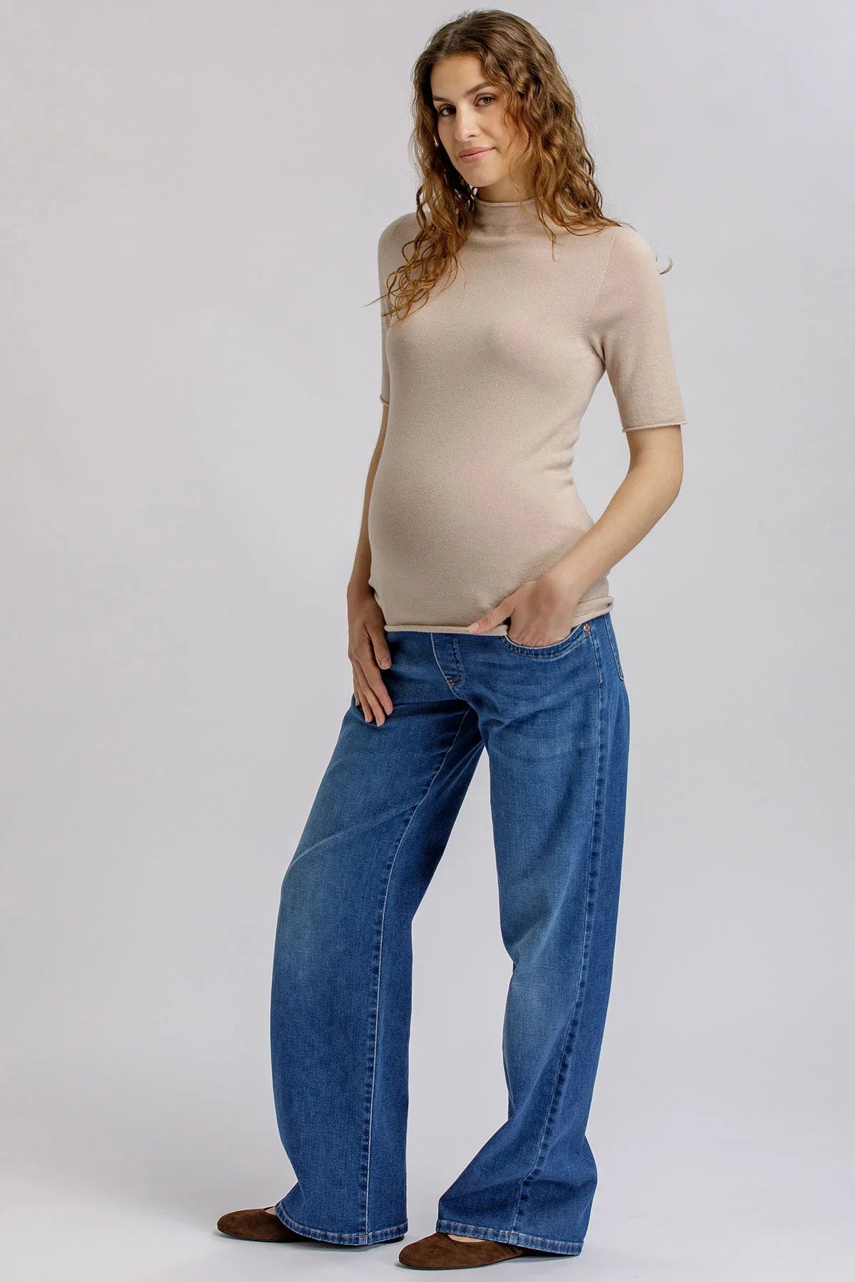 Maglia premaman beige elegante con collo alto.