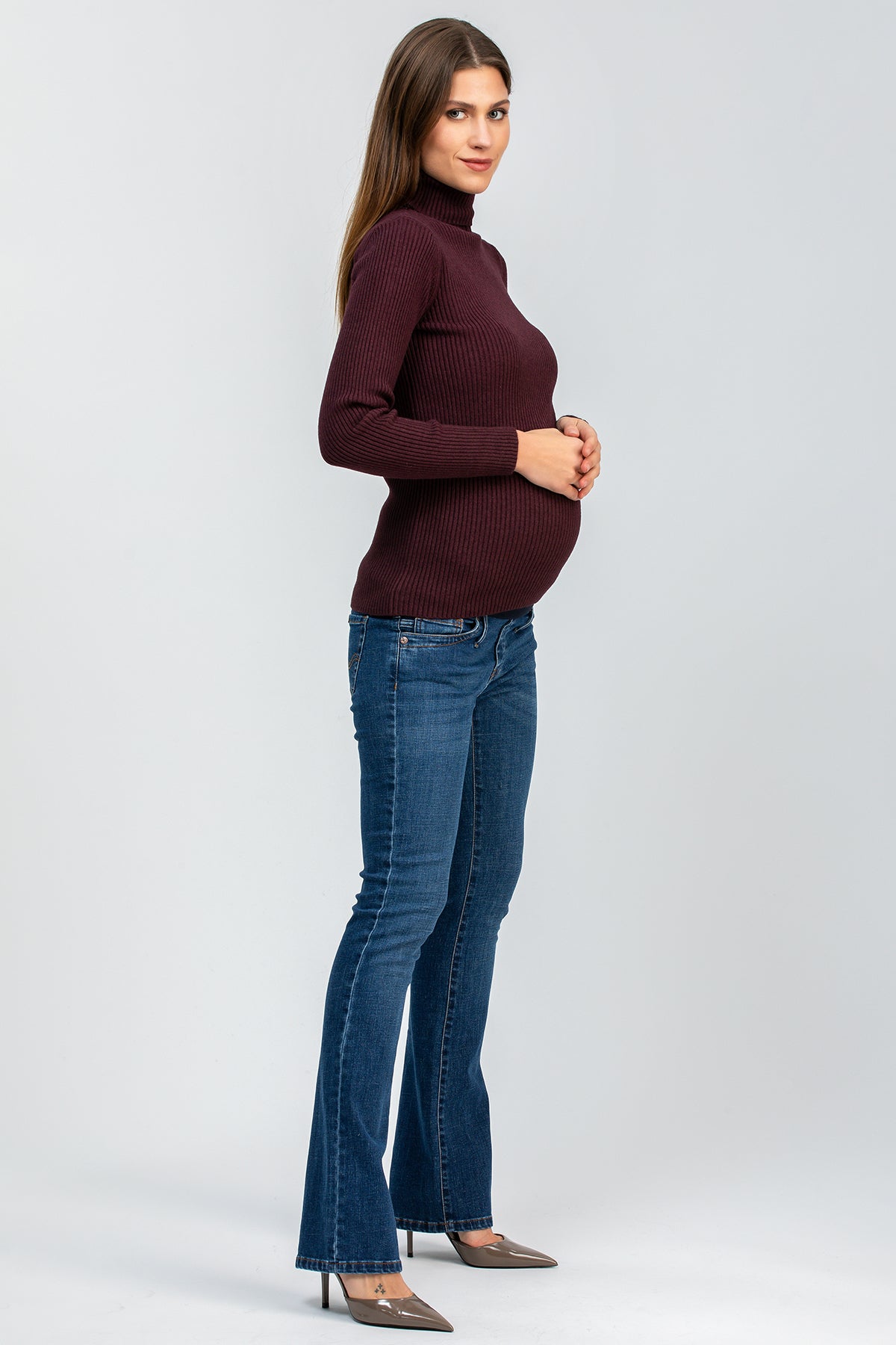 Donna incinta con maglione bordeaux e jeans premaman bootcut per gravidanza