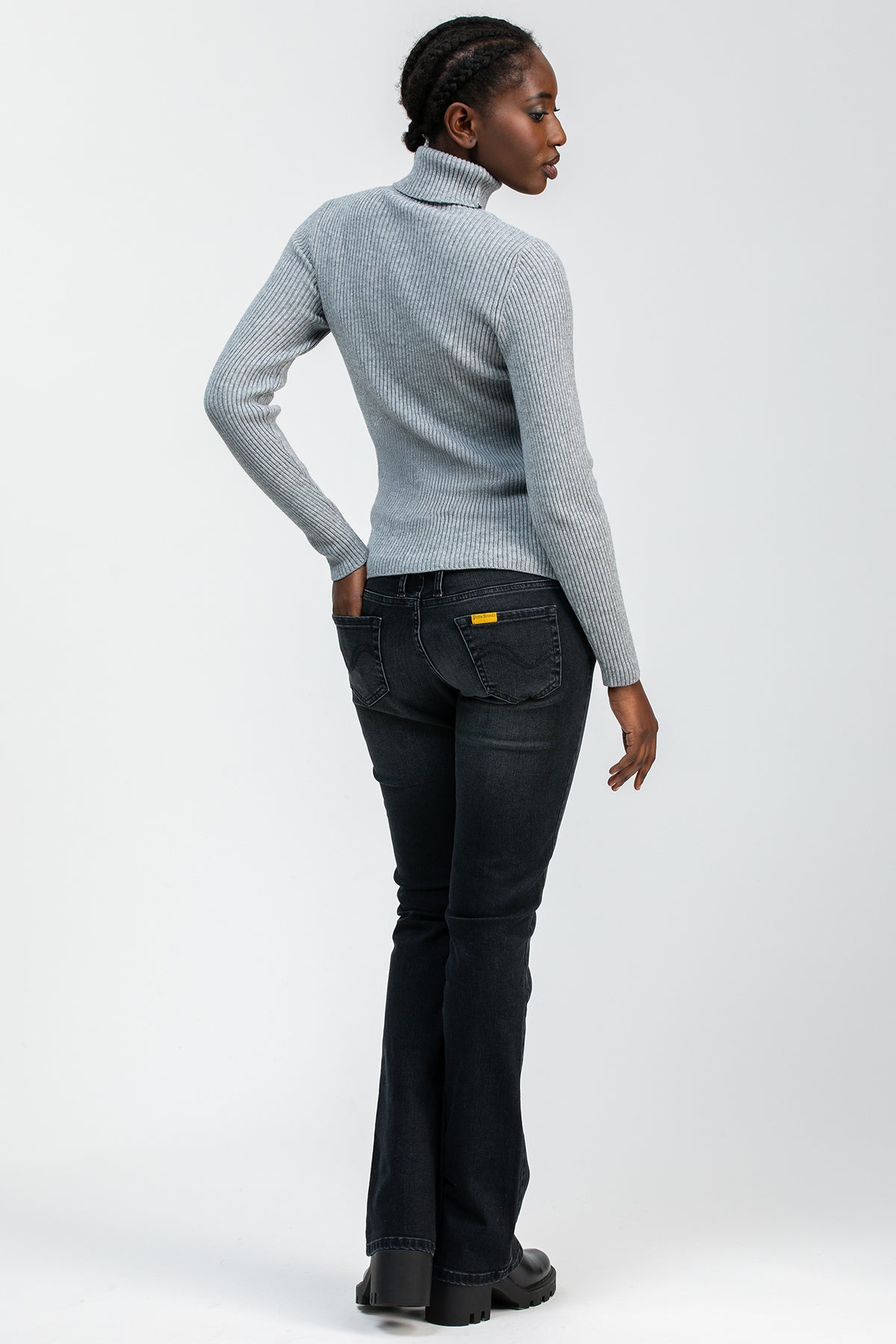 Donna con maglione grigio a coste e jeans neri slim bootcut premaman