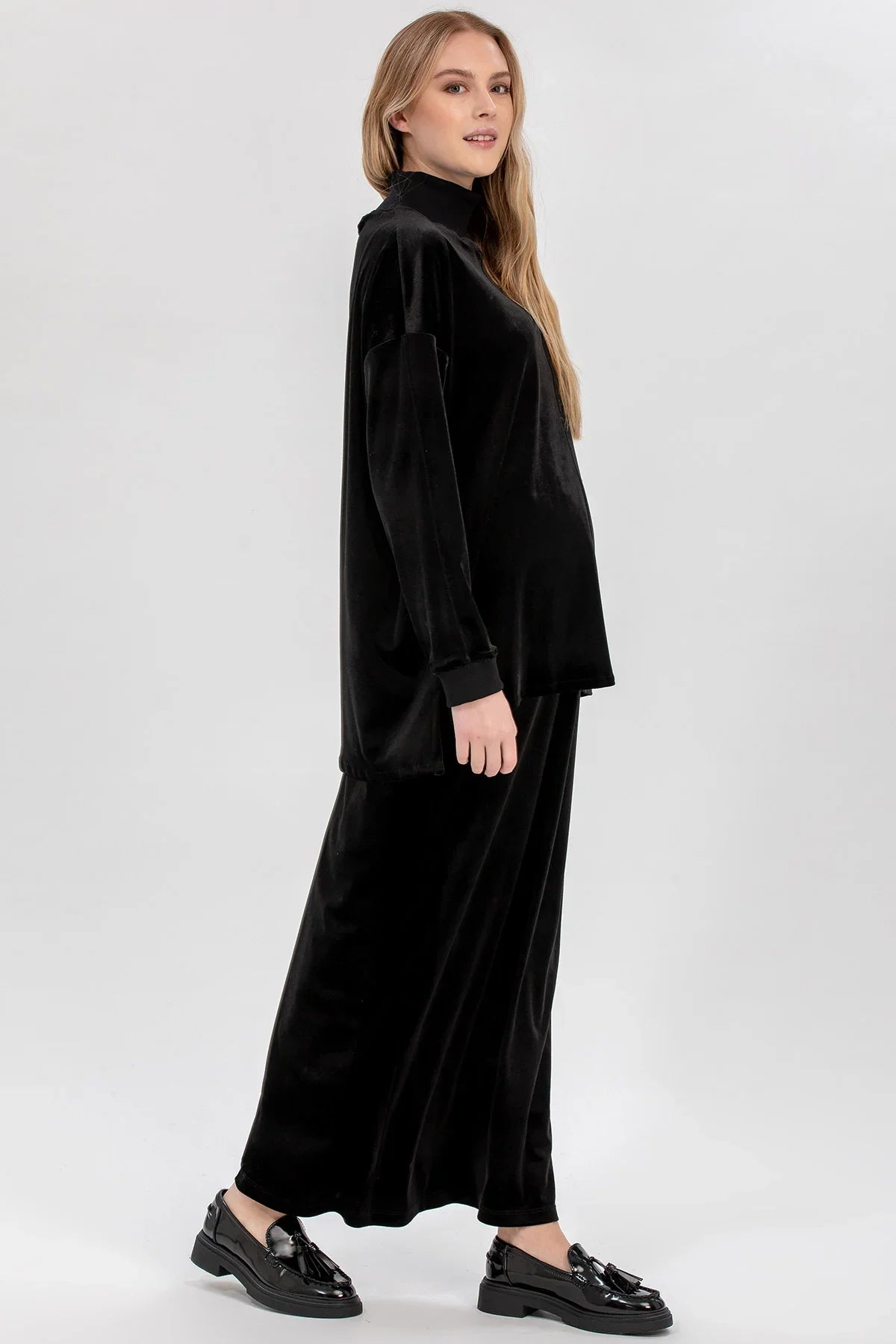 Modella indossa completo premaman nero in velluto, look elegante e confortevole gravidanza