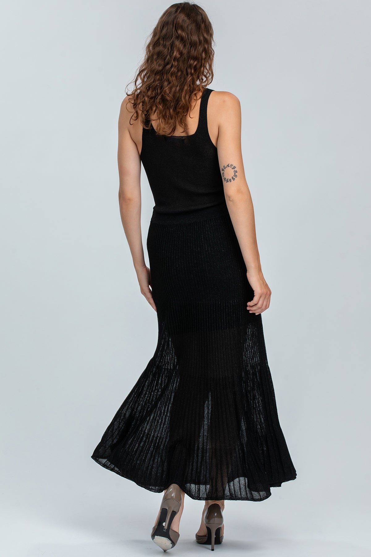 Abbigliamento premaman elegante, donna con abito lungo nero senza maniche, tessuto leggero.