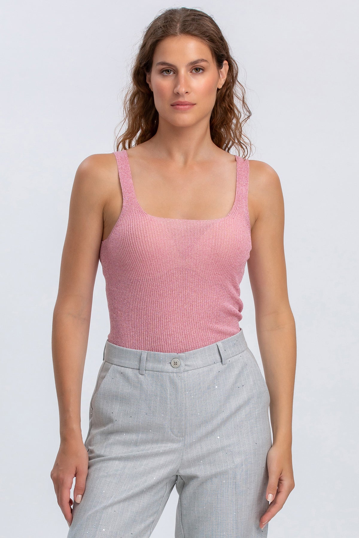 Top premaman rosa smanicato in maglia con pantaloni grigi, abbigliamento maternità elegante