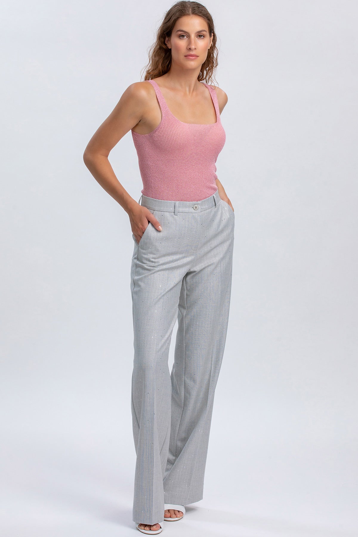 Donna con top premaman rosa e pantaloni premaman grigi eleganti, moda premaman