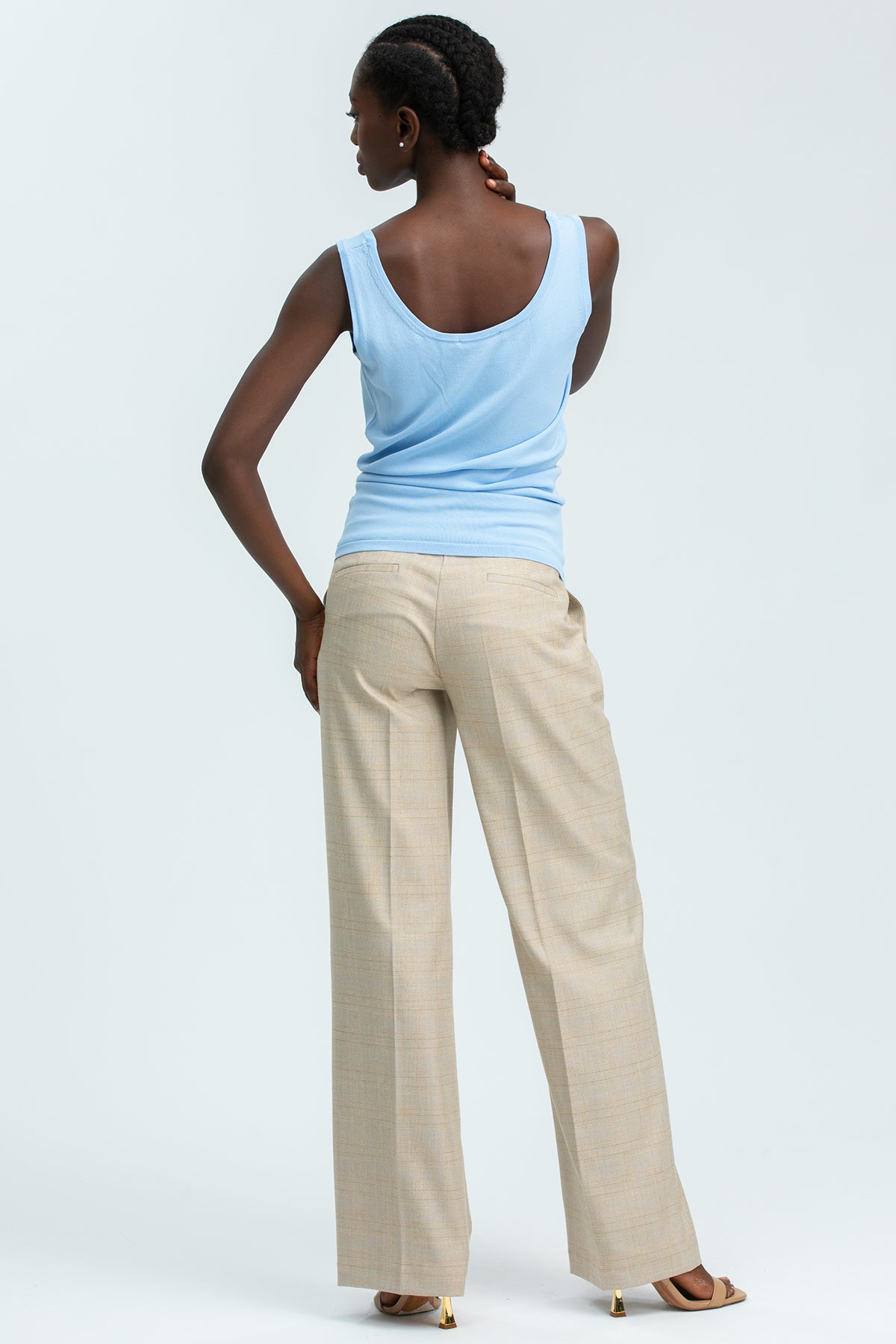 Pantaloni premaman beige a gamba ampia e top premaman azzurro senza maniche, look elegante.