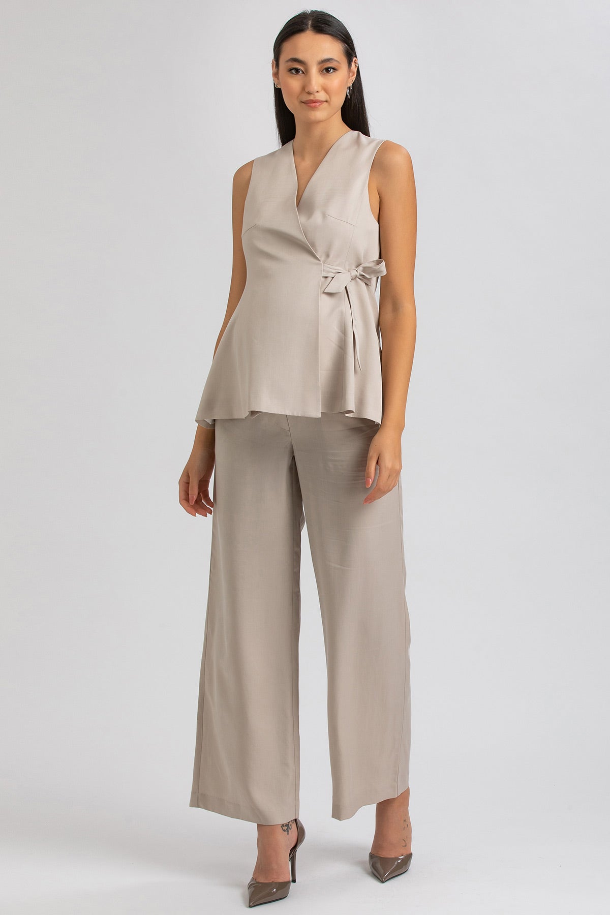 Completo premaman elegante beige, top smanicato con fiocco e pantaloni larghi.